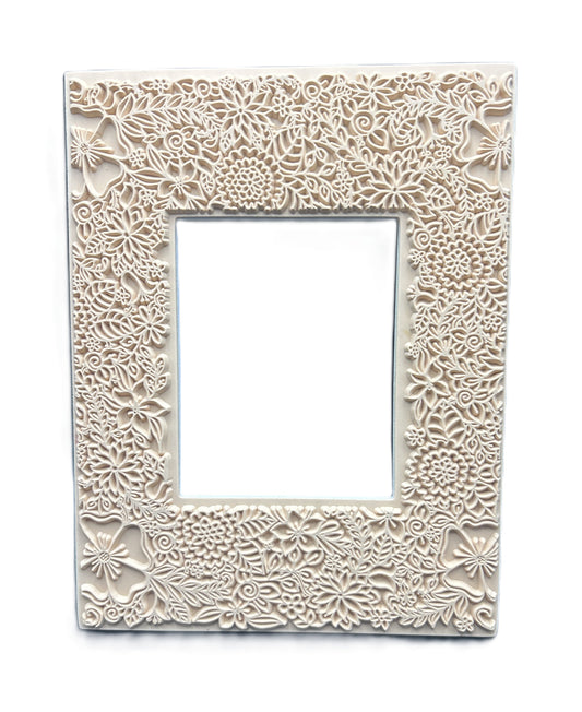 Decorative white frame with intricate floral patterns on a white background