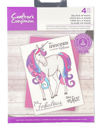 Packaging of Crafter's Companion unicorn-themed stamps on a wooden surface