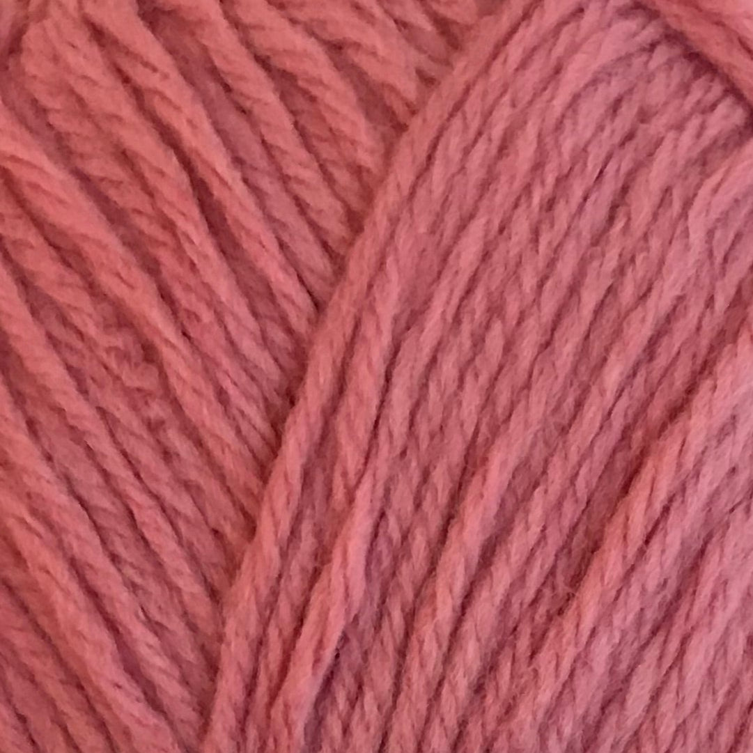 Ball of pink yarn with a label on a light background