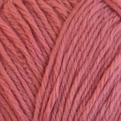 Ball of pink yarn with a label on a light background