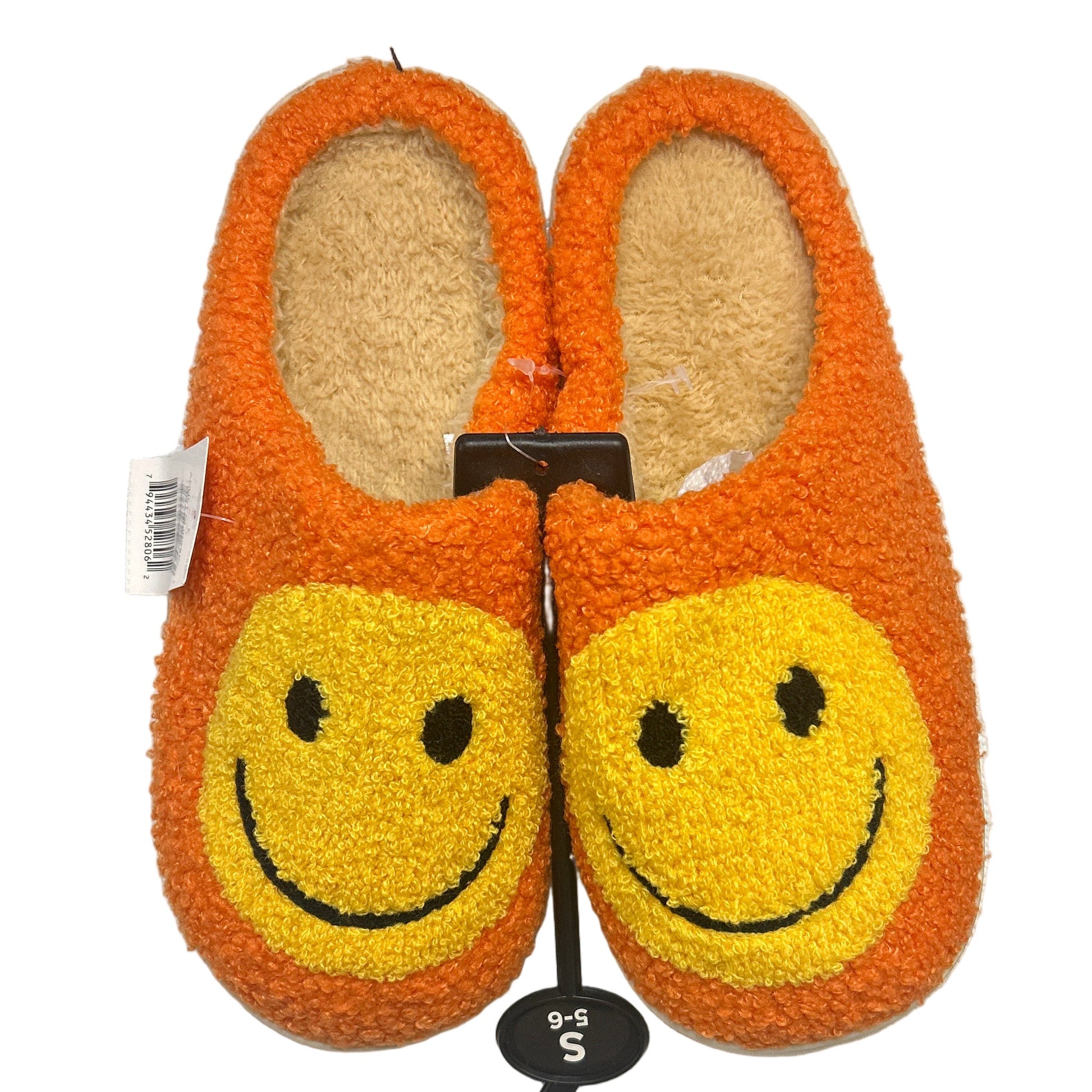 Pair of orange slippers with smiley face design on a white background