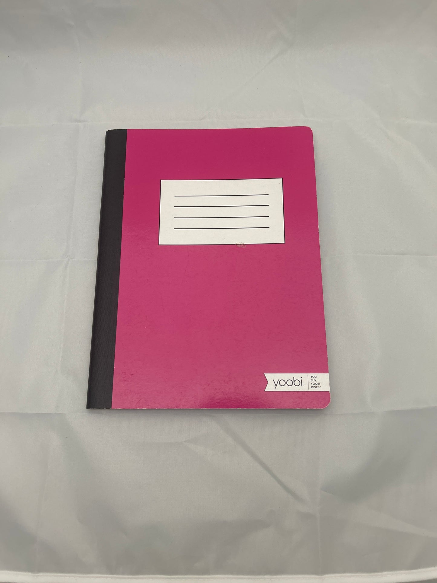 Pink notebook with a white label on a gray background