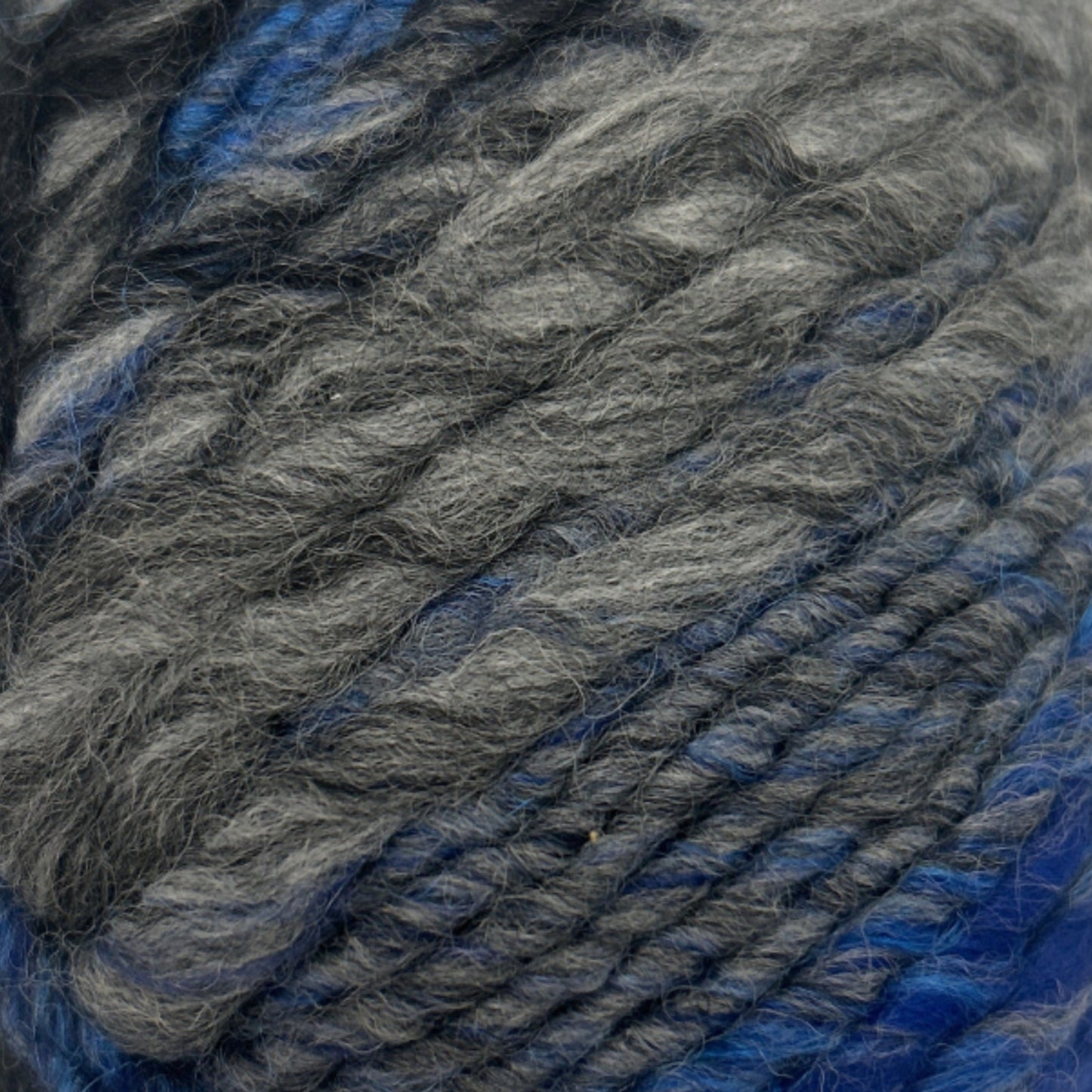 Ball of gray and blue yarn on a white background