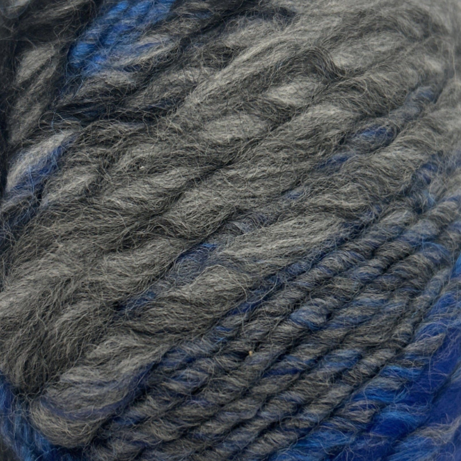 Ball of gray and blue yarn on a white background