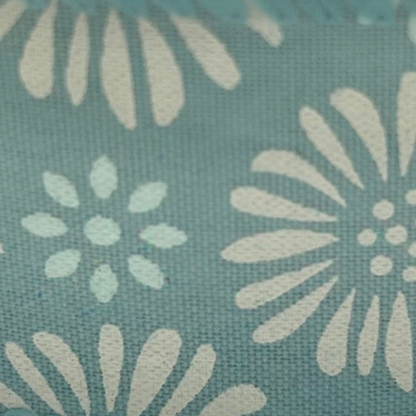 Roll of ribbon with floral pattern on a light blue background