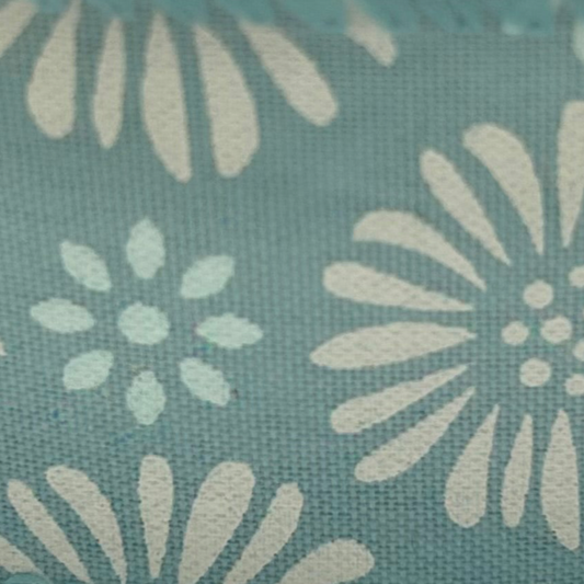 Roll of ribbon with floral pattern on a light blue background