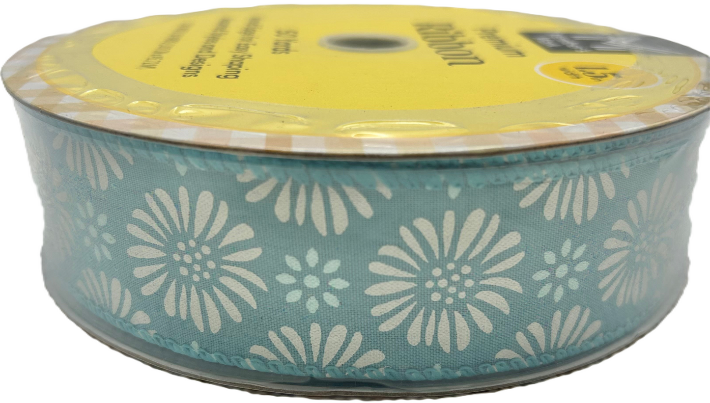 Spool of ribbon with floral pattern on a white background