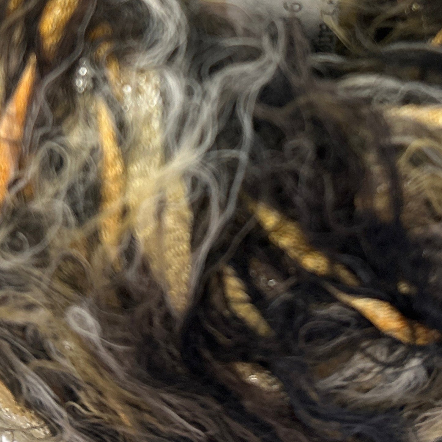 Close-up of a skein of yarn with brown, black, and gray colors.