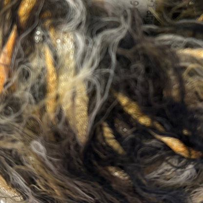 Close-up of a skein of yarn with brown, black, and gray colors.