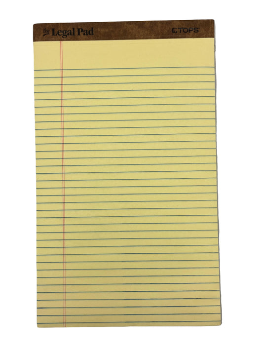 Yellow legal pad with lines on a gray background