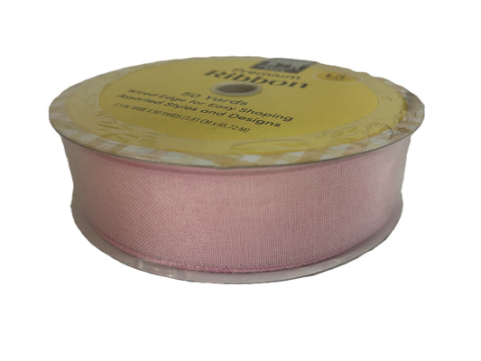 Spool of pink ribbon with a yellow label on a white background