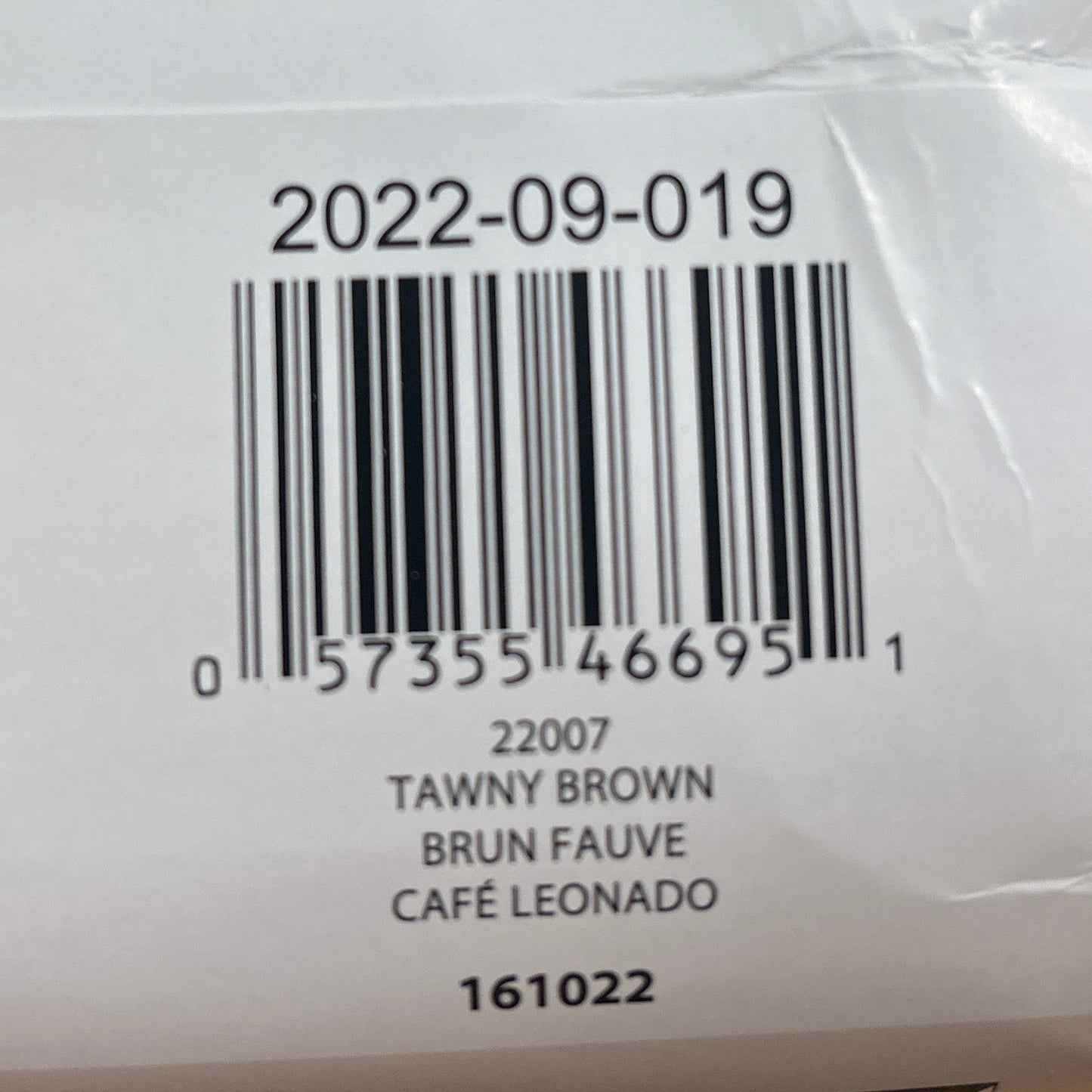 Close-up of a label on a textured fabric product with a barcode and text.
