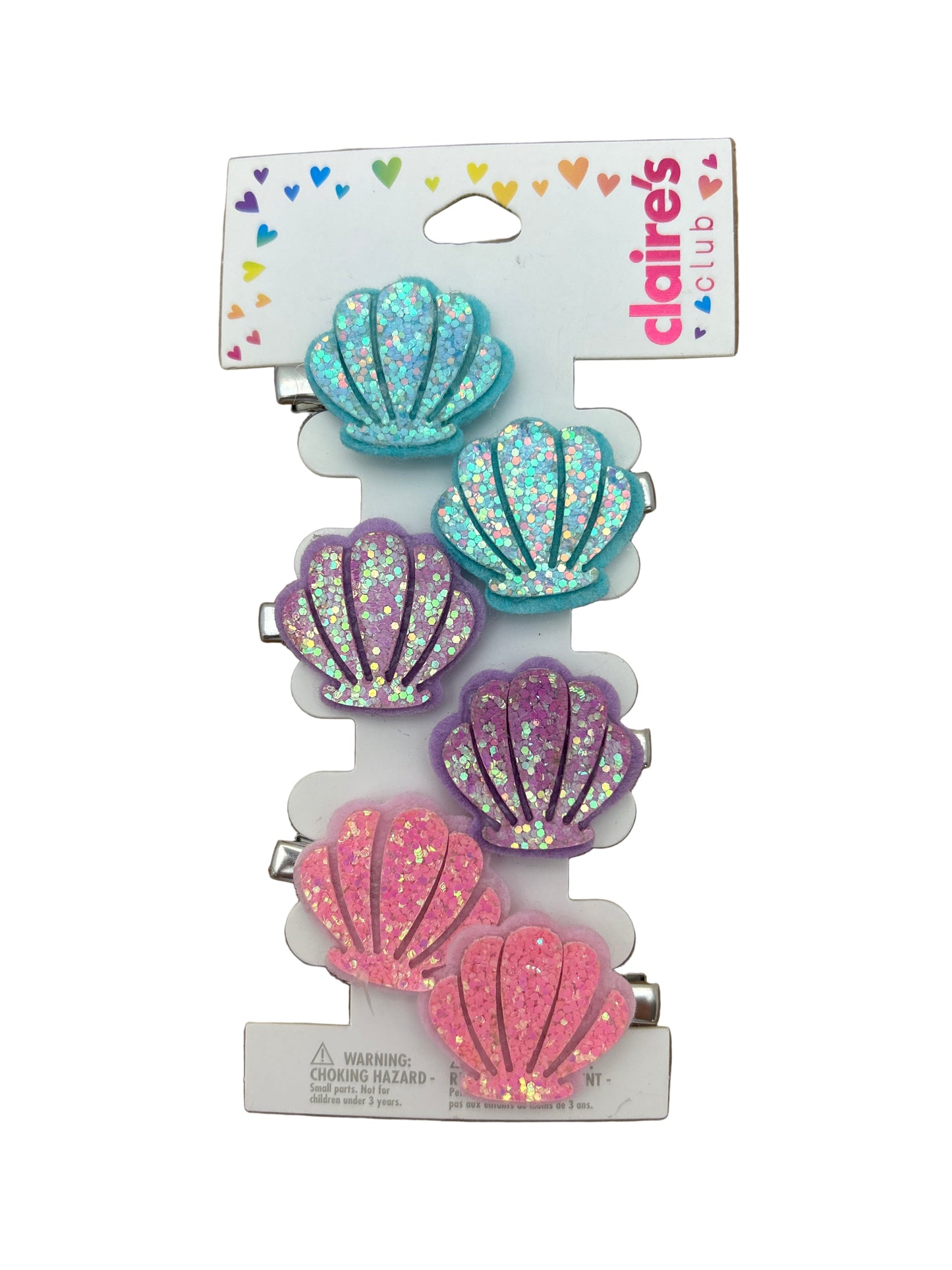 Set of five colorful shell-shaped hair clips on a Daisies branded card against a brown background