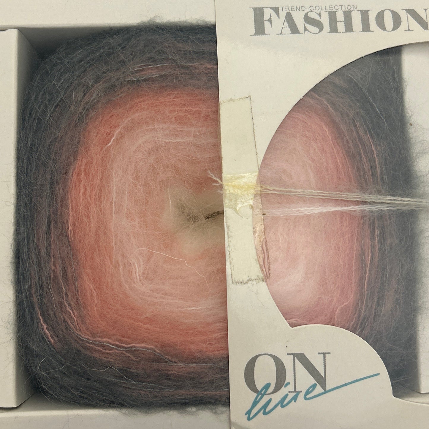 Ball of yarn in a packaging box with visible brand name.