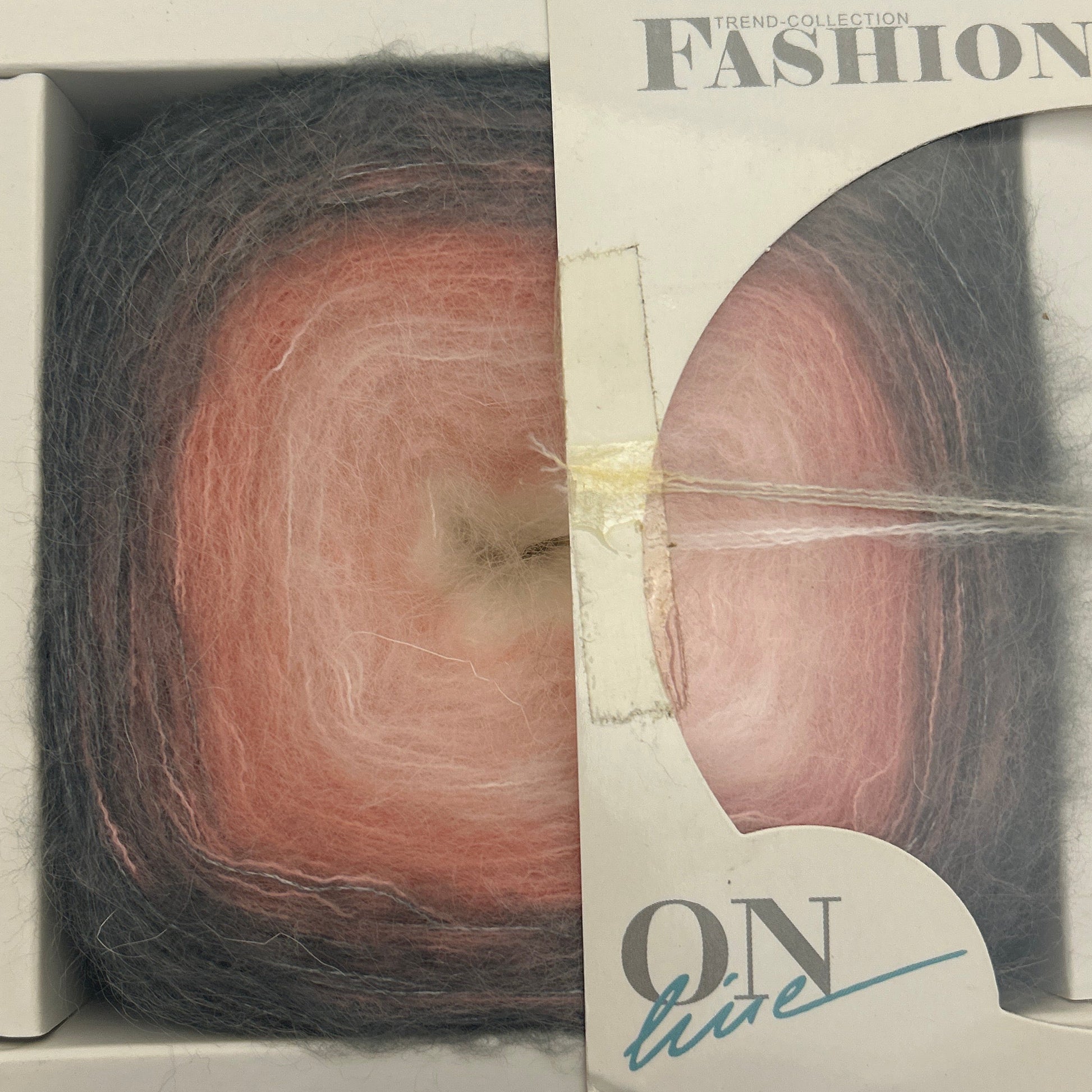 Ball of yarn in a packaging box with visible brand name.