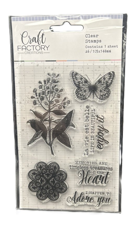 Packaged clear stamps with butterfly, floral, and decorative text design on a white background.