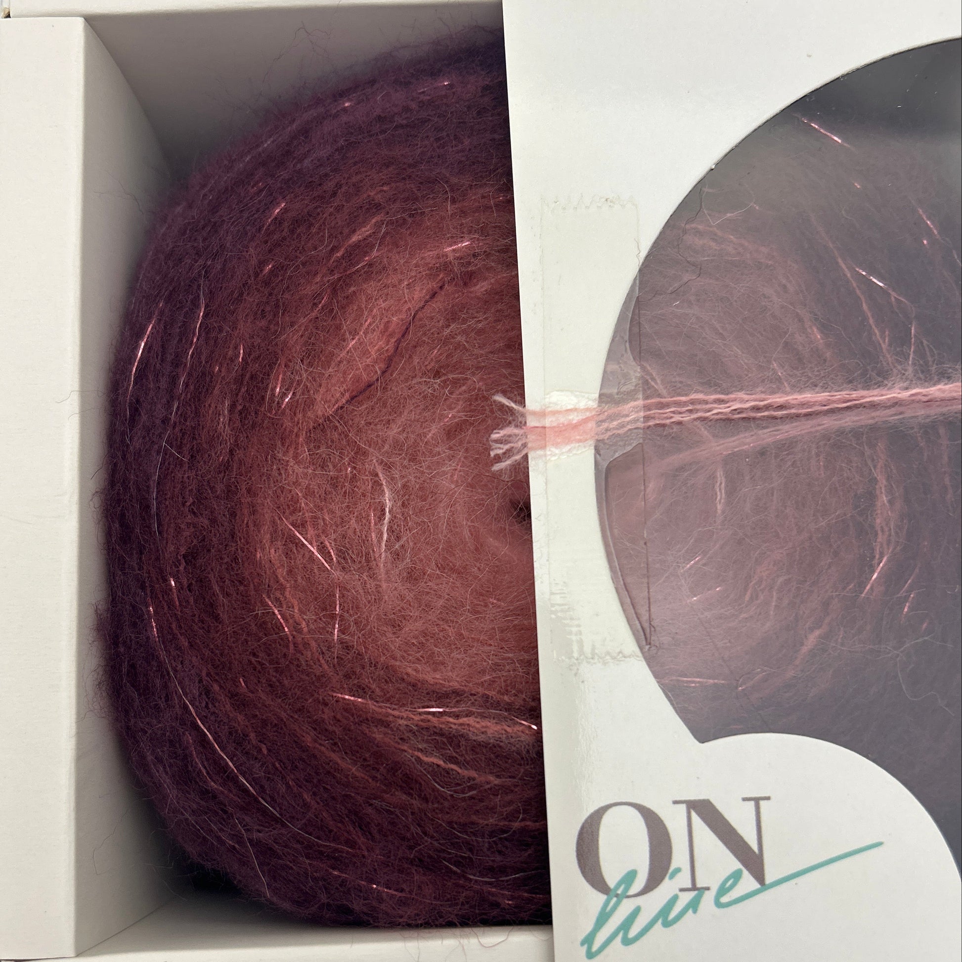 Ball of yarn in a box with 'Fashion' branding on a gray background