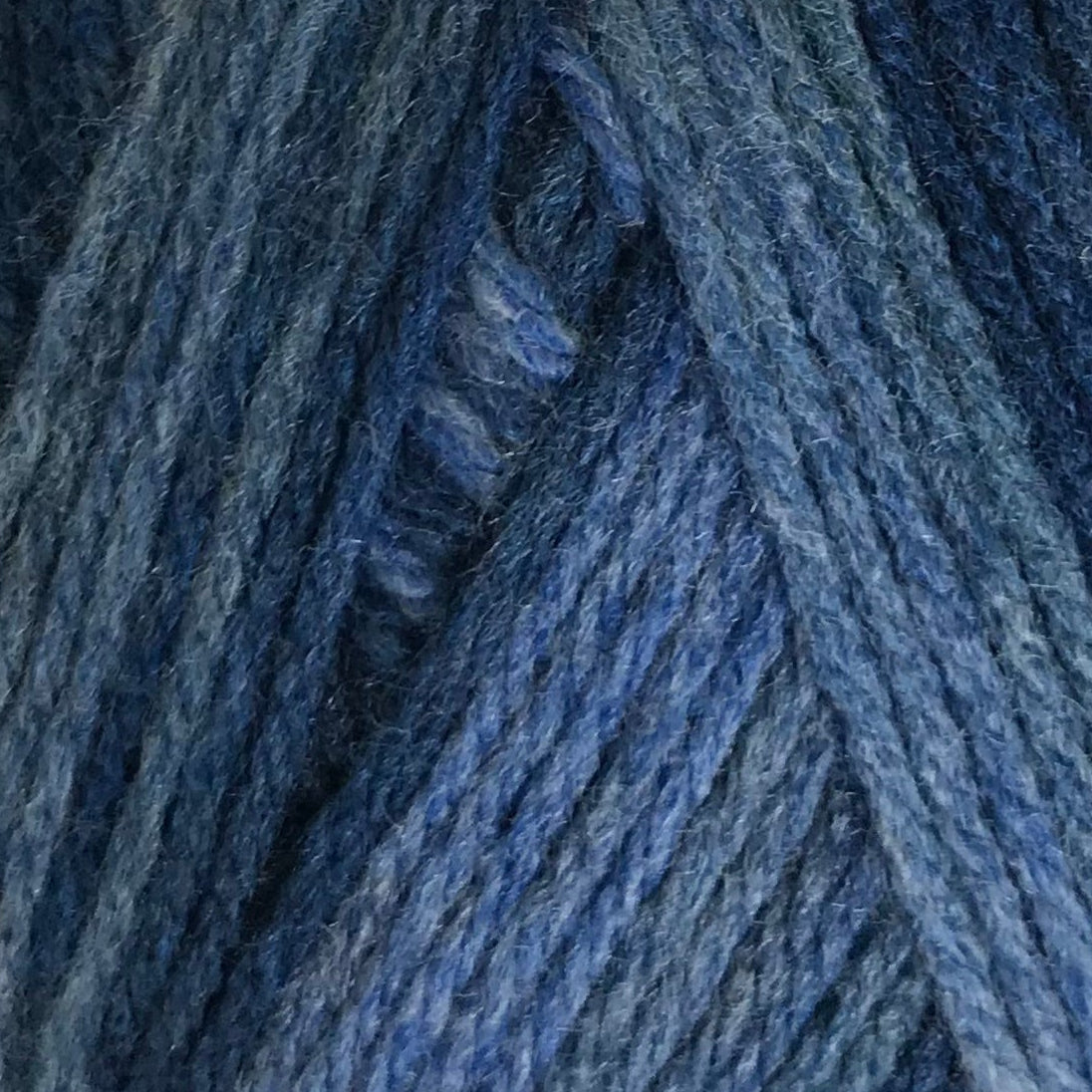 Blue skein of yarn with a label on a white background