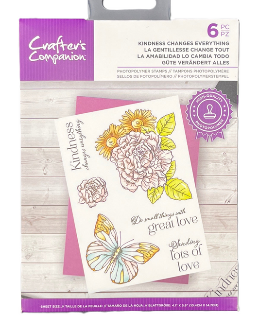 Packaging of Crafters Companion stamps with floral and butterfly designs on a wooden surface.