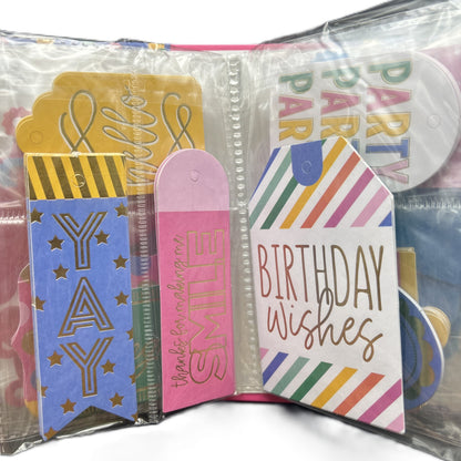 Collection of colorful birthday-themed cards and tags in a clear plastic case.