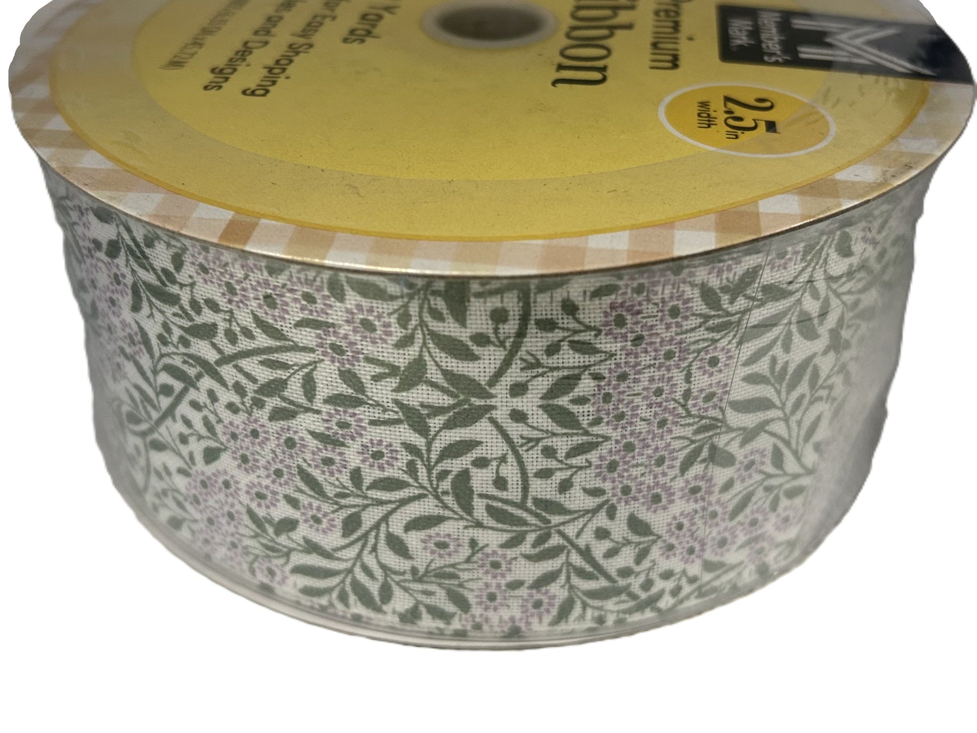 Spool of floral-patterned ribbon with a yellow label on a white background