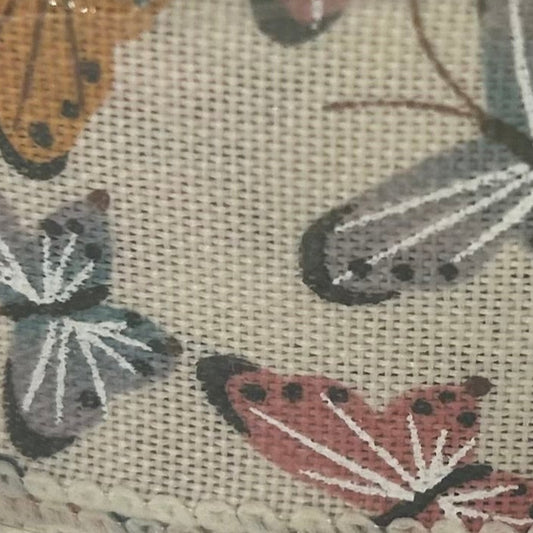 Close-up of fabric with embroidered butterflies on a beige background