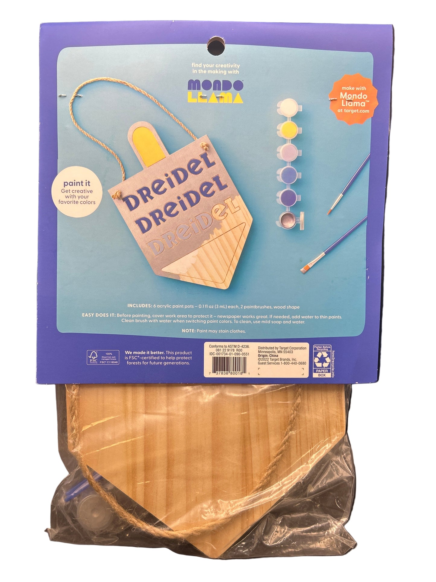 Craft kit packaging with wooden discs on a dark surface