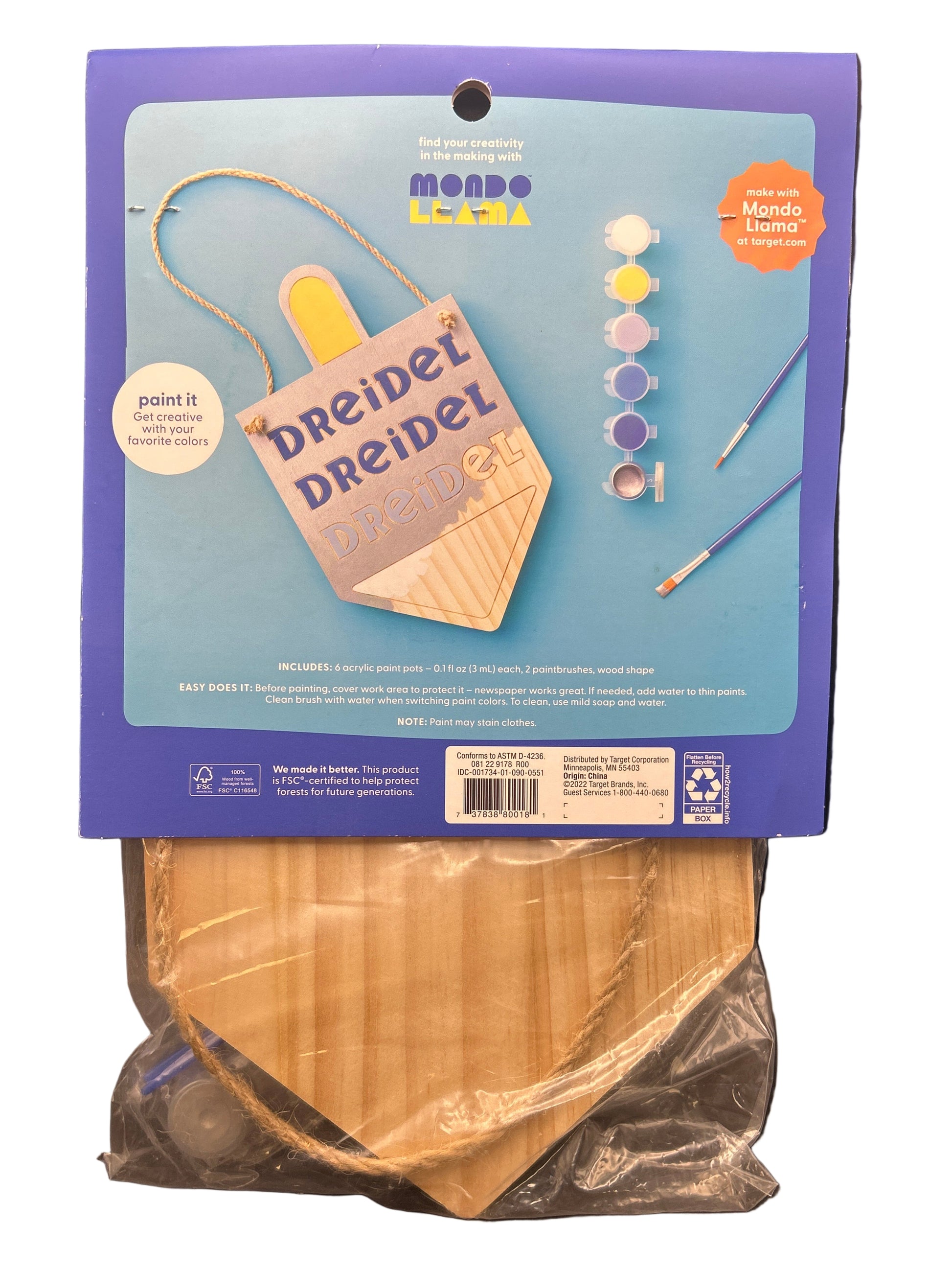 Craft kit packaging with wooden discs on a dark surface