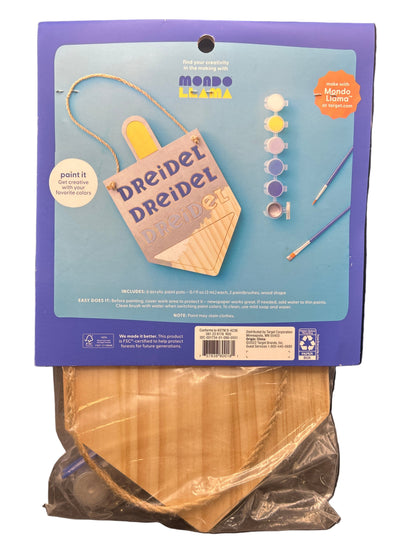 Craft kit packaging with wooden discs on a dark surface