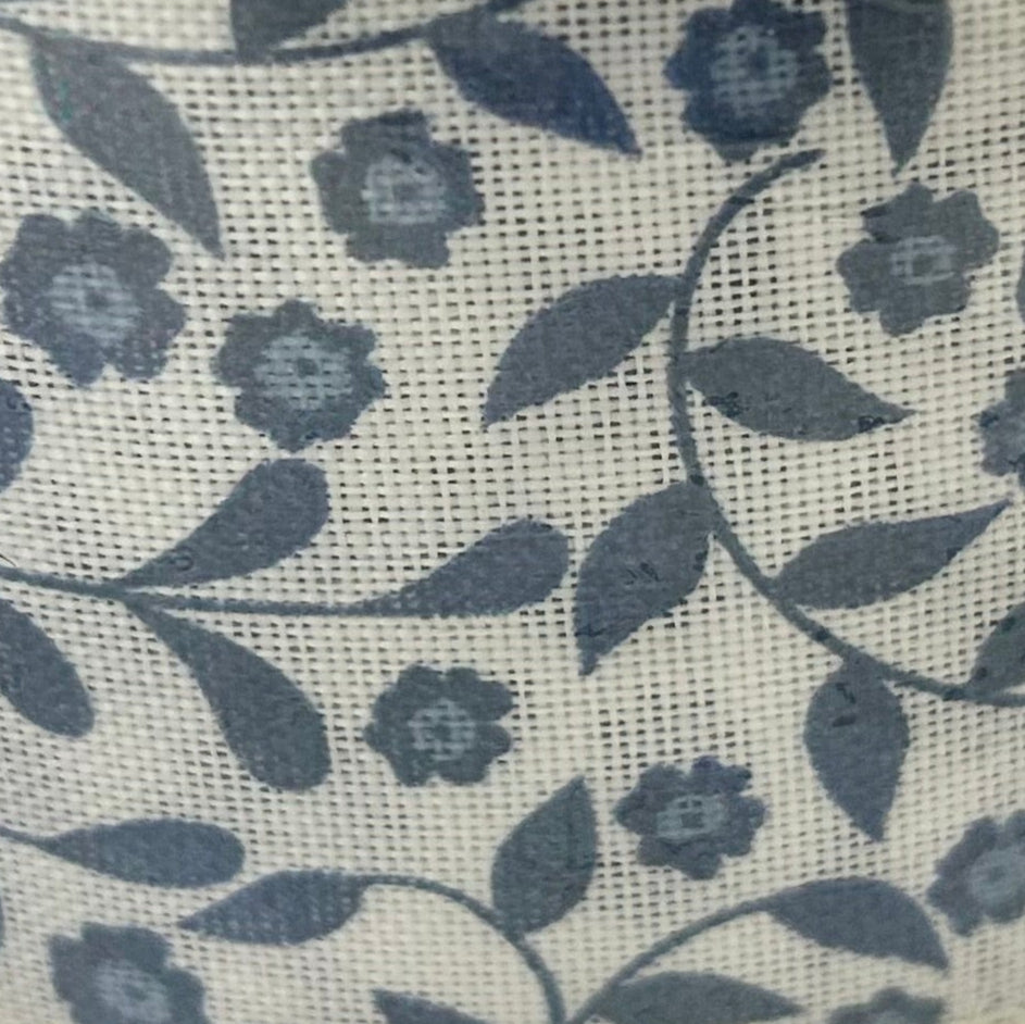 Floral pattern with blue flowers and green leaves on a textured beige background
