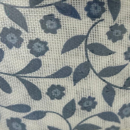 Floral pattern with blue flowers and green leaves on a textured beige background