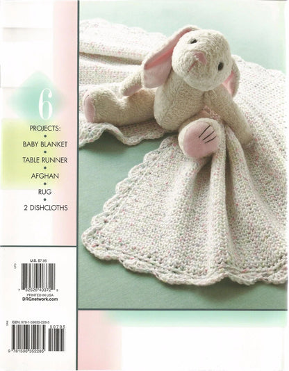 Crocheted bunny toy with blanket on a light green background