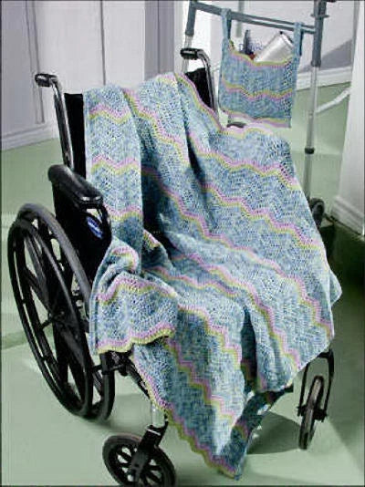 Knitted blanket draped over a wheelchair on a light green floor.