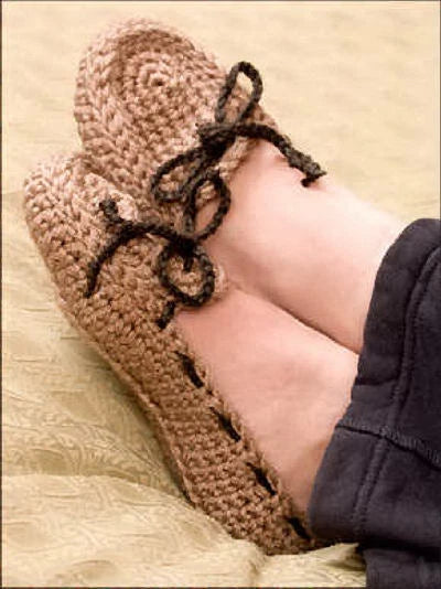 Brown knitted slippers being worn on a light-colored surface