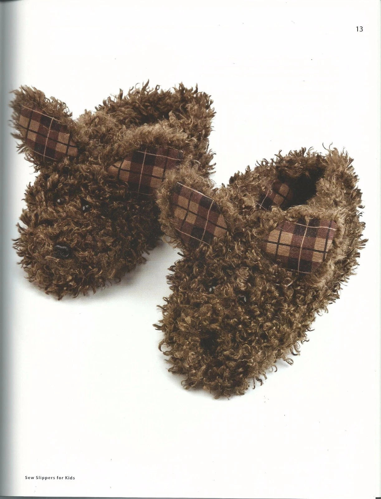 Pair of brown fuzzy slippers with plaid accents on a white background