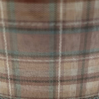 Close-up of plaid fabric with brown, green, and beige colors.