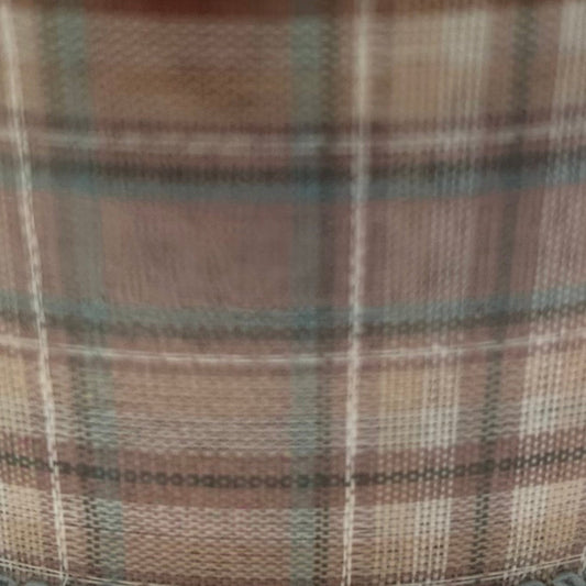 Close-up of plaid fabric with brown, green, and beige colors.