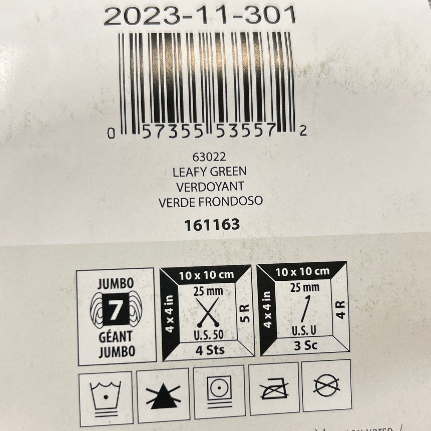 Close-up of a label on green yarn with text and symbols.