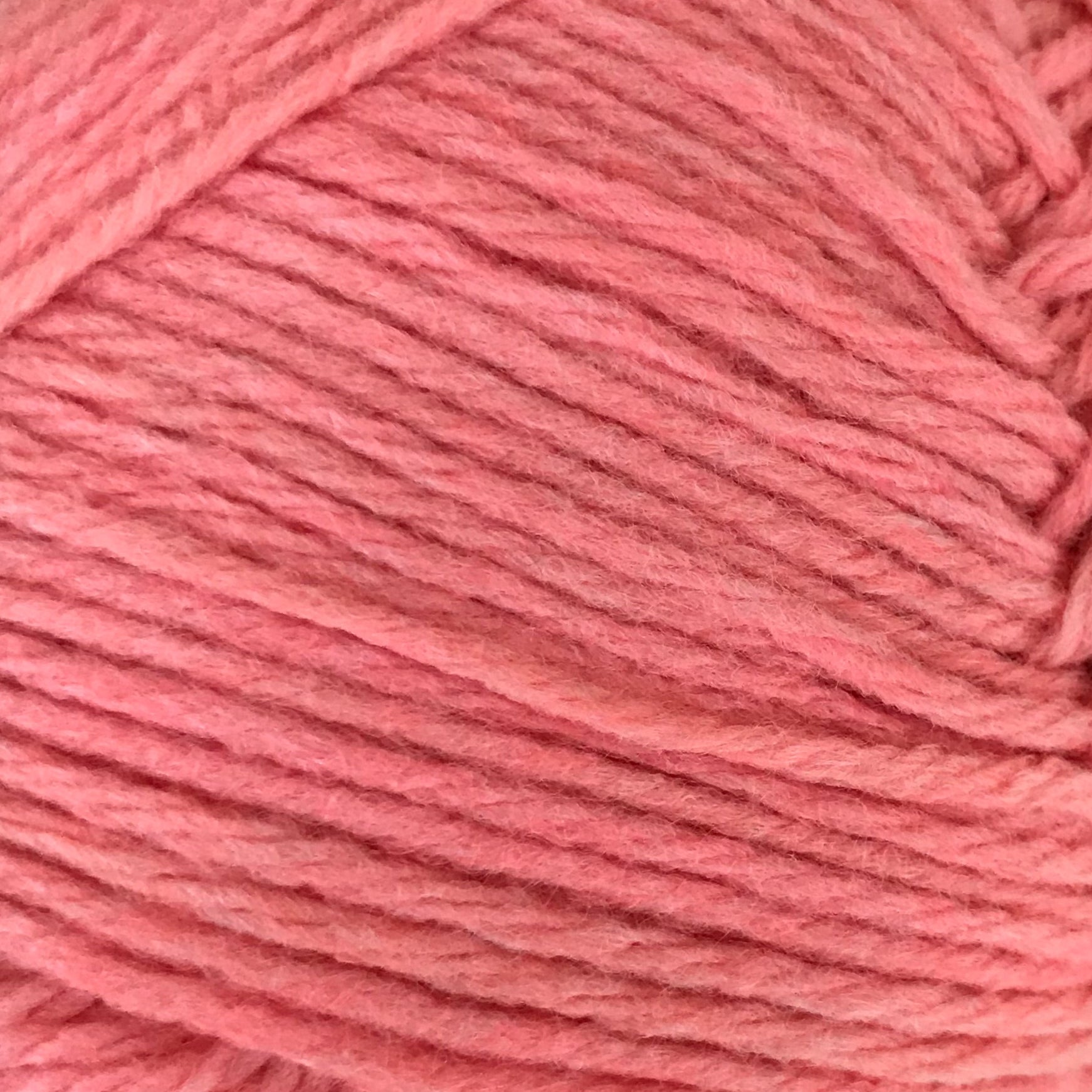 Ball of pink yarn on a gray background