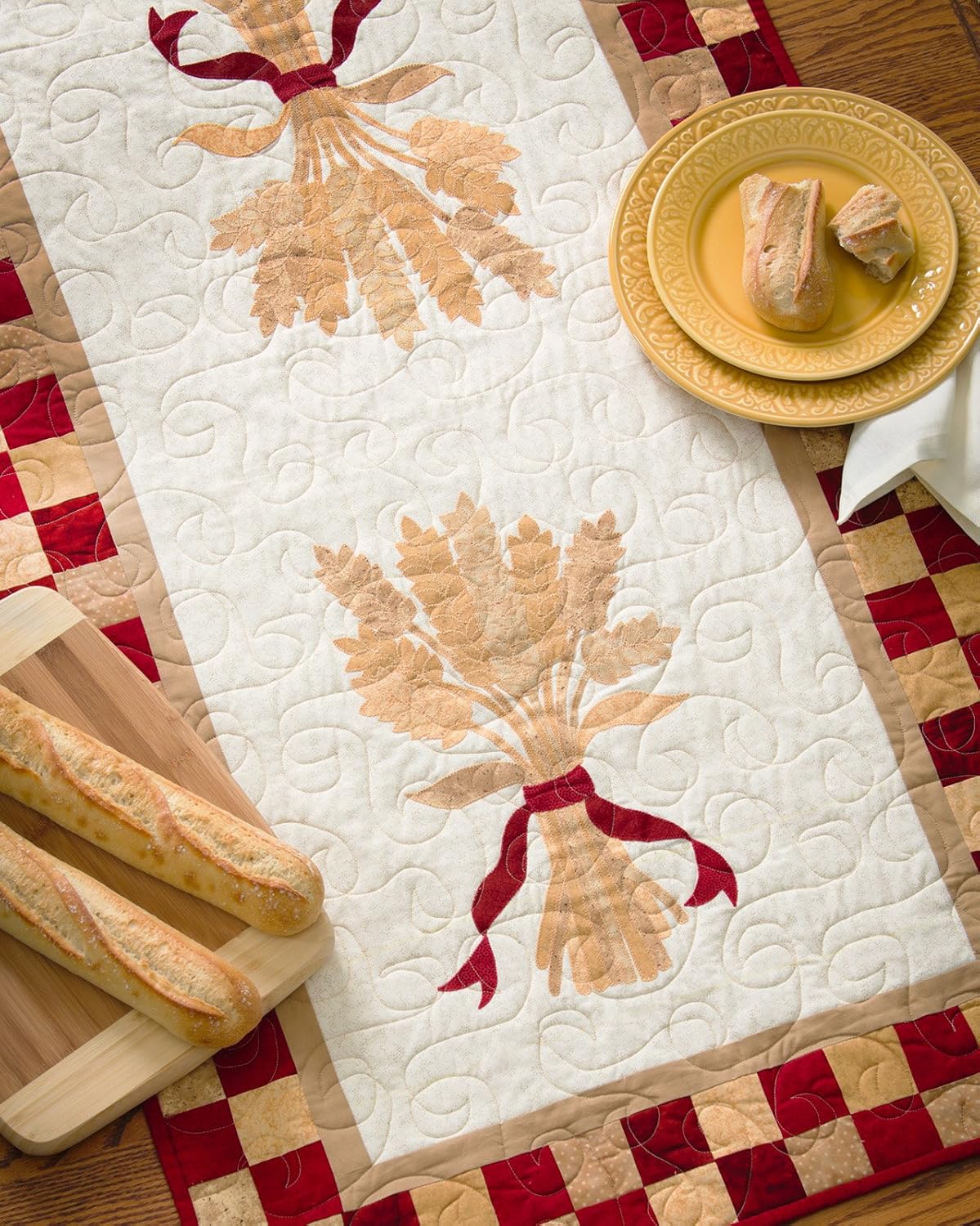 Quilted table runner with bread design on a checkered tablecloth