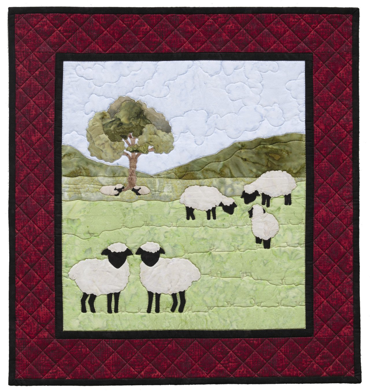 Quilt with sheep and tree design on a red border