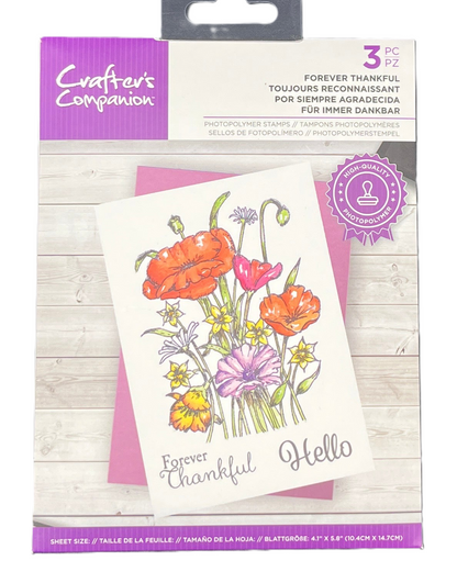Packaged floral stamp set with 'Forever Thankful Hello' text on a wooden surface