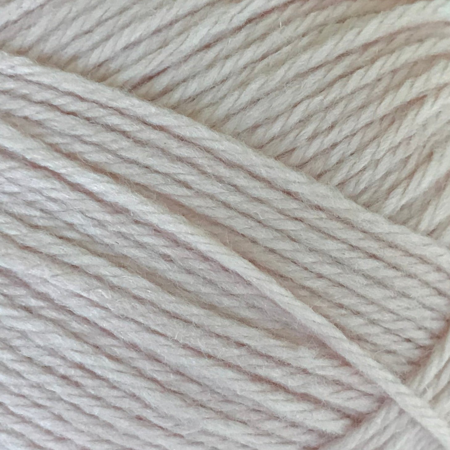 Close-up of beige yarn with a slight gradient.