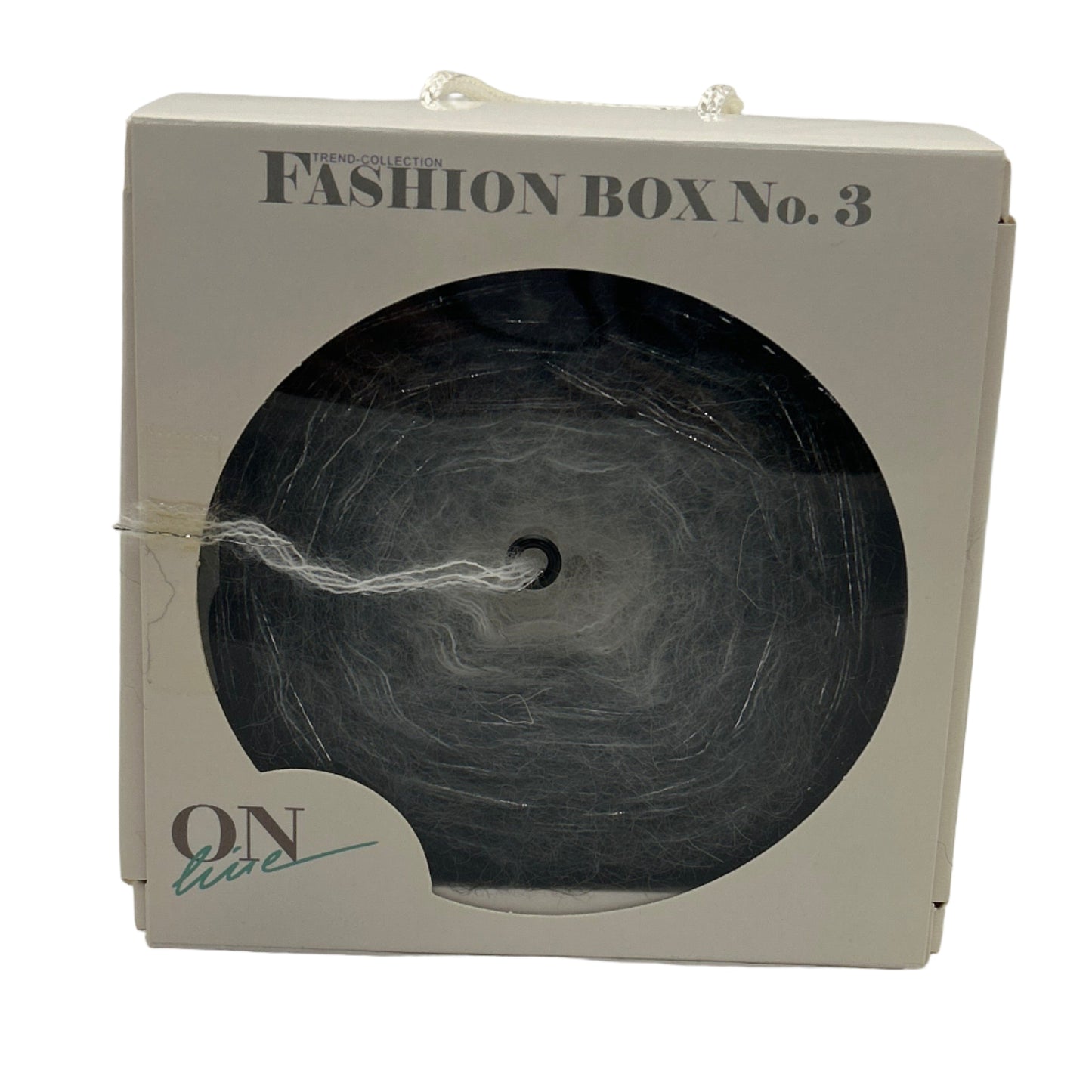 Fashion box labeled 'Fashion Box No. 3' with a black yarn ball inside on a white background