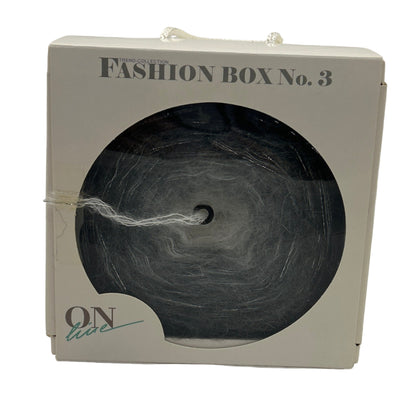 Fashion box labeled 'Fashion Box No. 3' with a black yarn ball inside on a white background