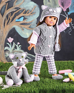 Doll in a crocheted outfit with a cat plush toy against a colorful background