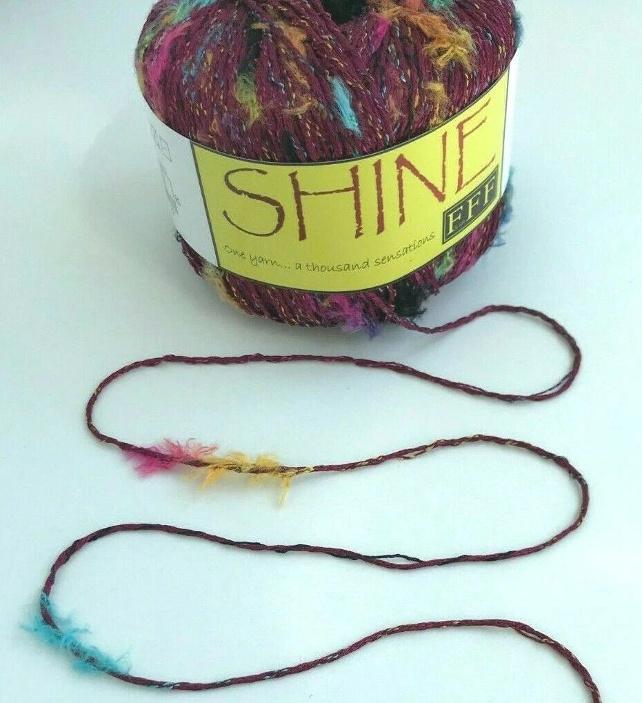 Colorful yarn ball with a 'Shine' label on a white background