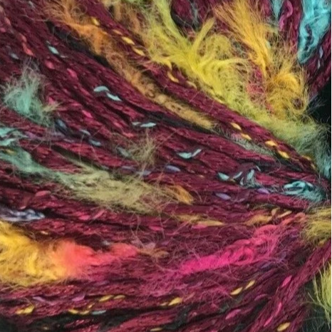Close-up of a skein of multicolored yarn with red, yellow, and pink hues.