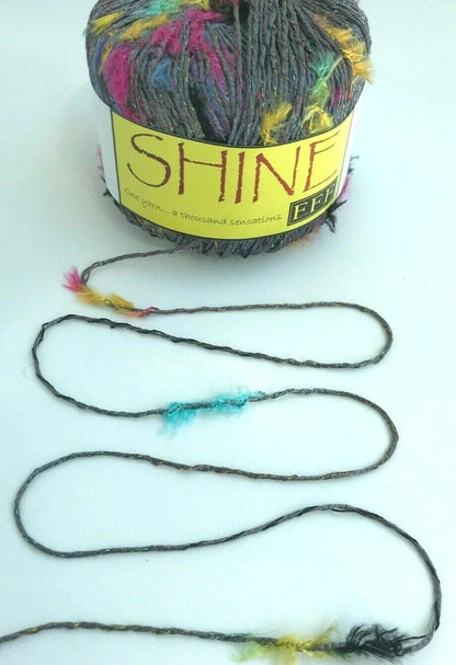Ball of yarn with colorful strands and a 'Shine' label on a white background