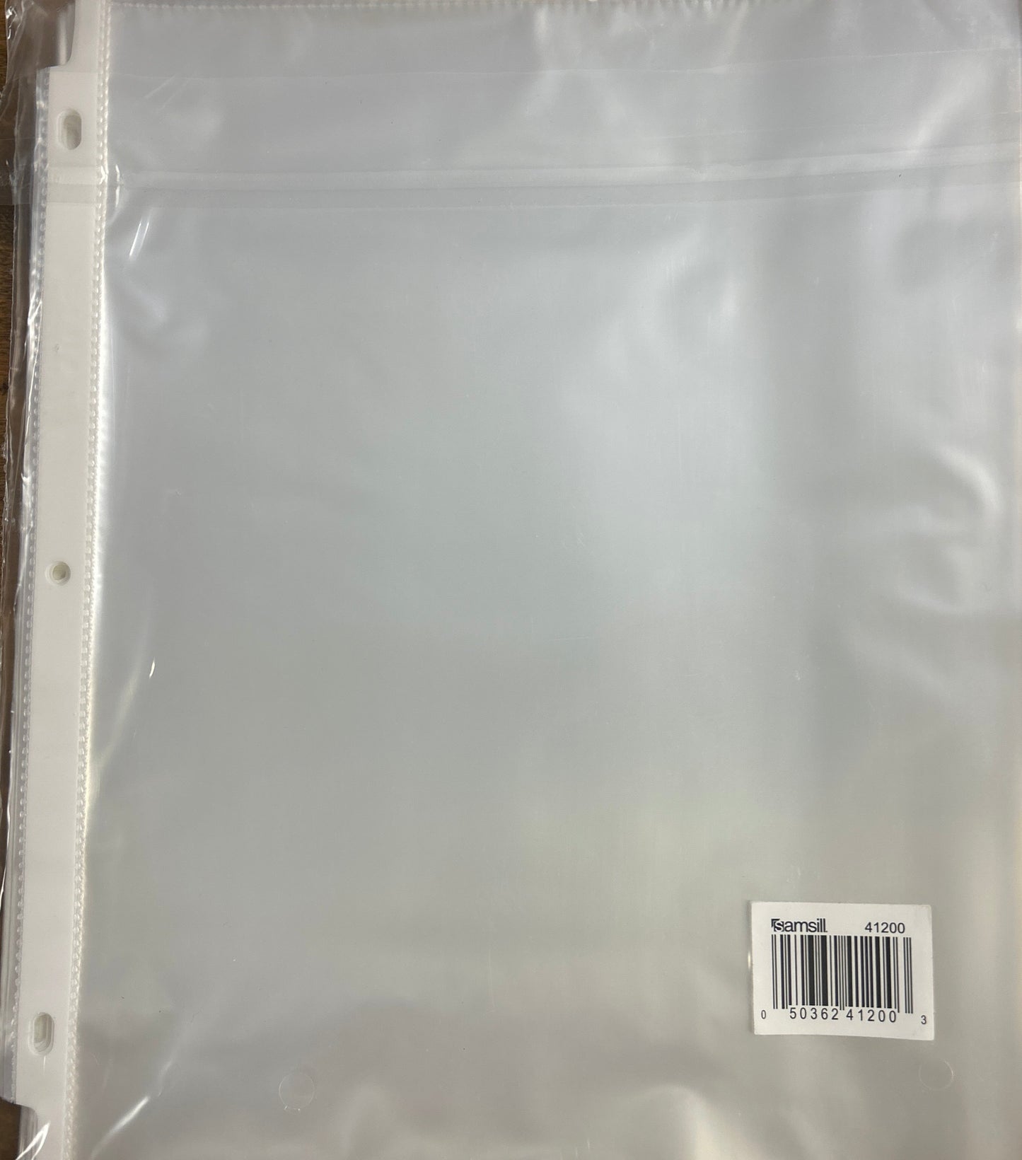 Clear plastic sheet with a barcode label on a wooden surface